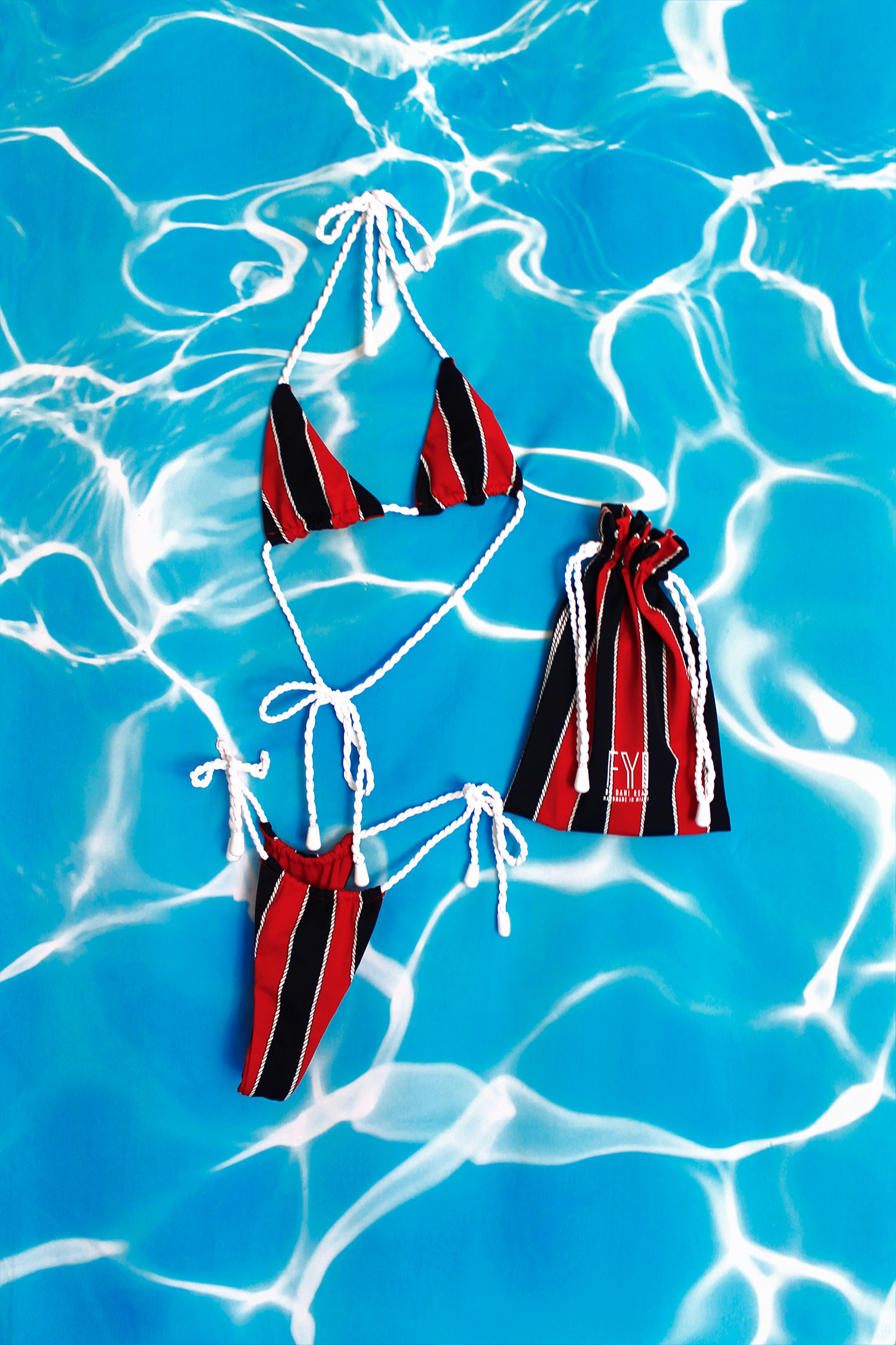 Red and black striped bikini set on a blue water background