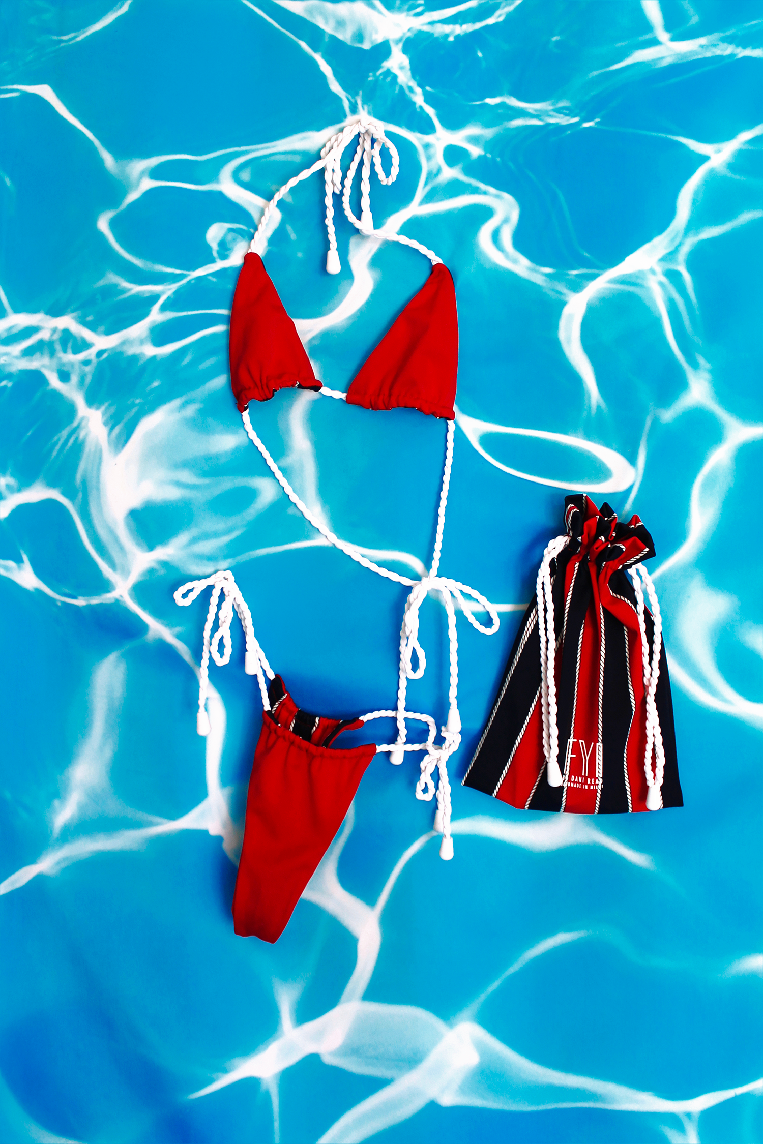 Red bikini set with matching bag on a blue water background