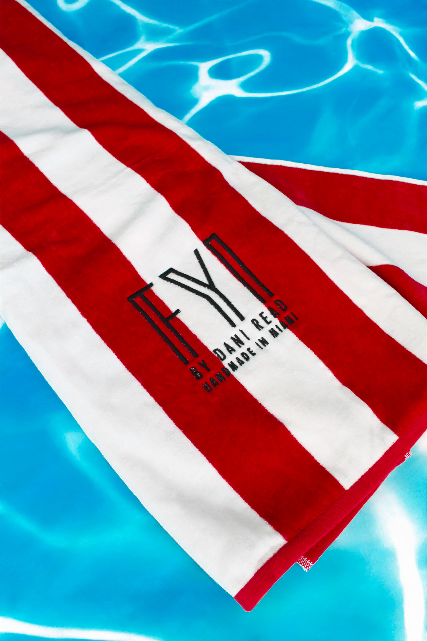Red and white striped towel with a logo on a blue water background